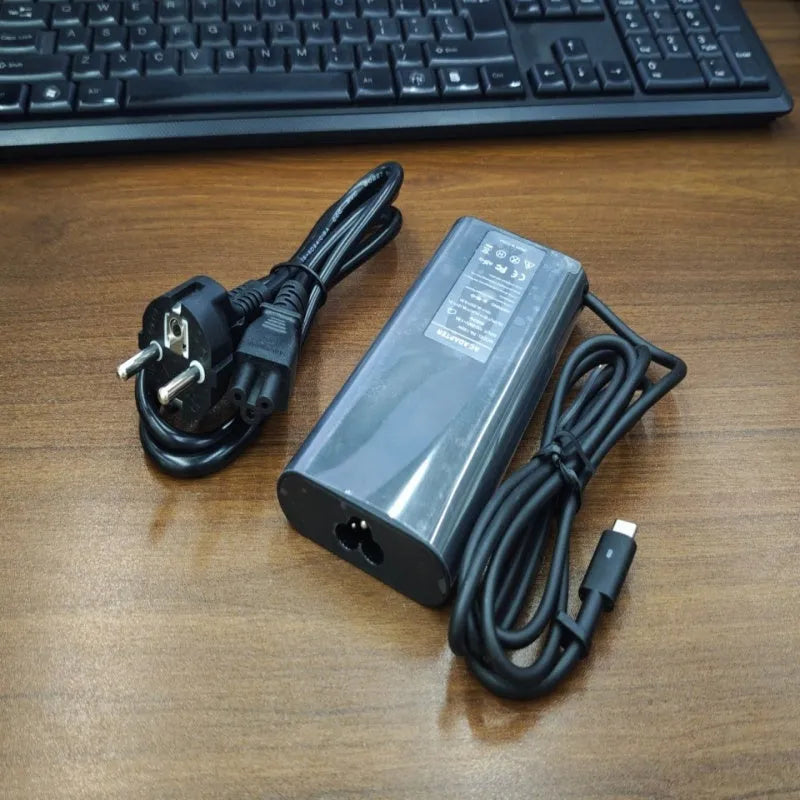 Black 65W Type-C laptop power adapter with a set of interchangeable international plug heads.