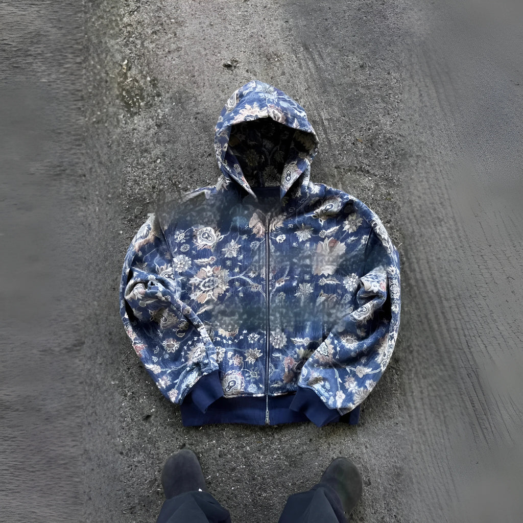 A man's loose-fitting red hooded zip coat with long sleeves, shown on a hanger.