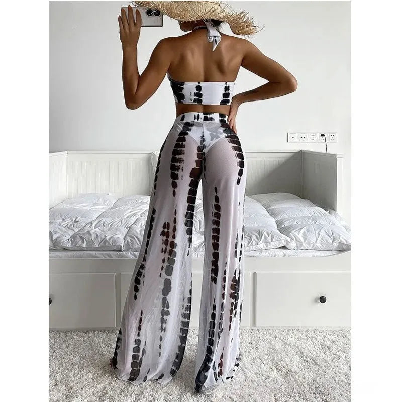 Women's black print three-piece bikini set with mesh trousers, top, and underpants on a mannequin.