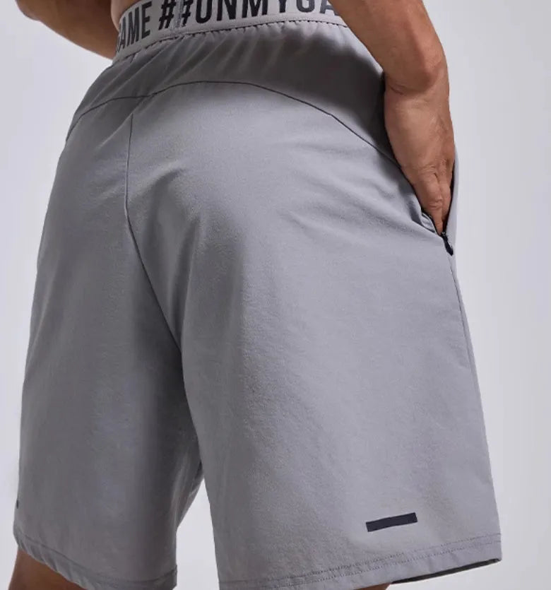 Men's grey workout shorts with loose cropped fit and letters detailing on elastic waist