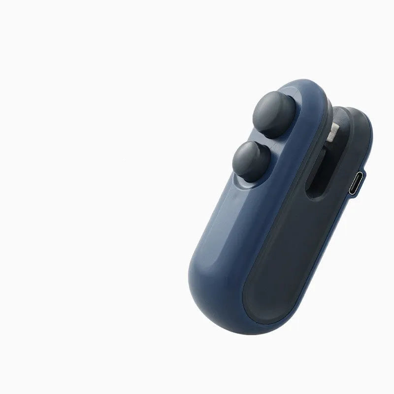 White handheld vacuum sealing machine with USB port and cutter blade on a kitchen counter.
