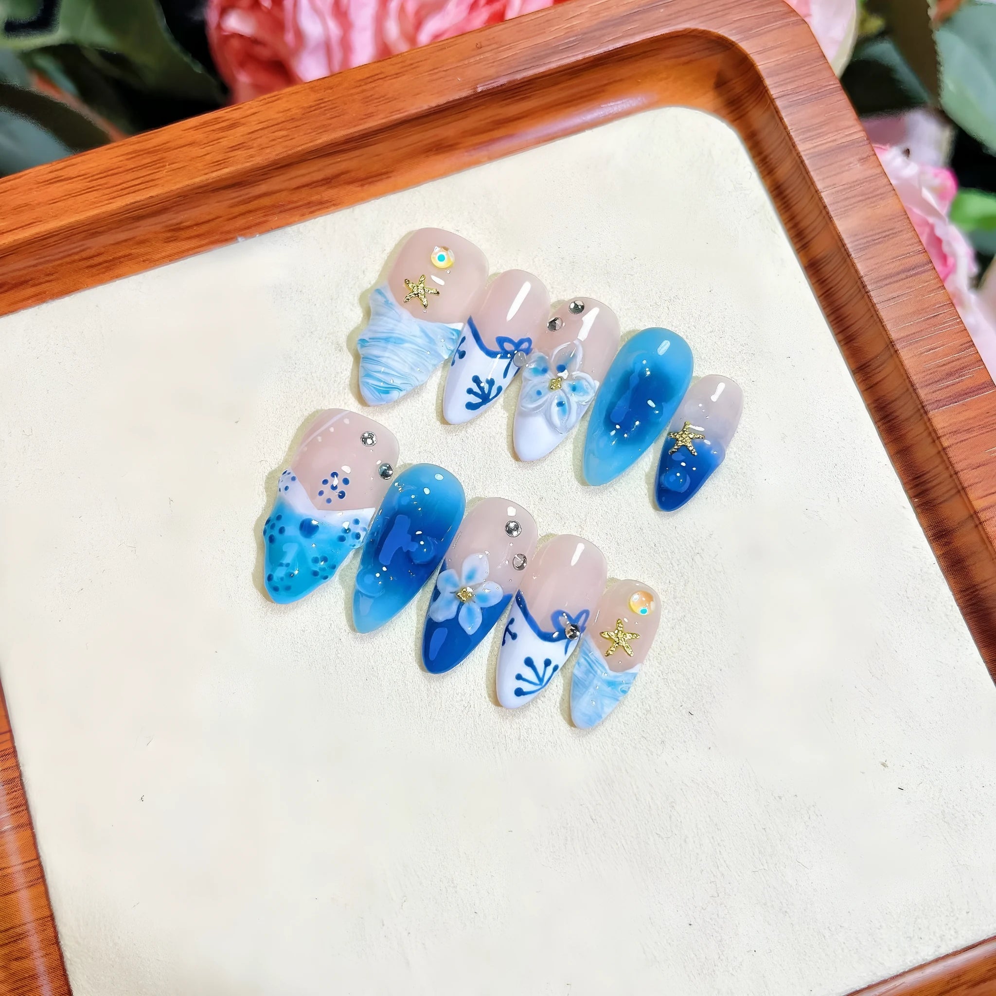 Set of blue hand-painted false nails with carved texture and a transparent summer ice aesthetic.