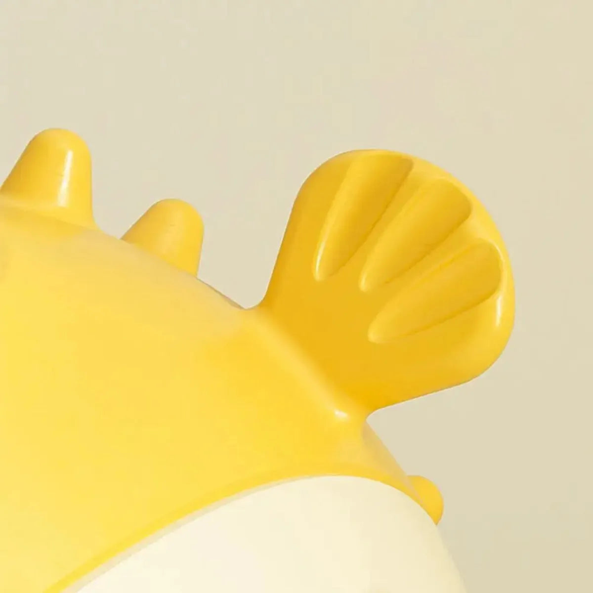Yellow vinyl fish-shaped dog chew toy with textured surface for dental care
