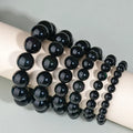 Hand-woven obsidian couple bracelet showing spherical black crystal beads in continuous strand construction