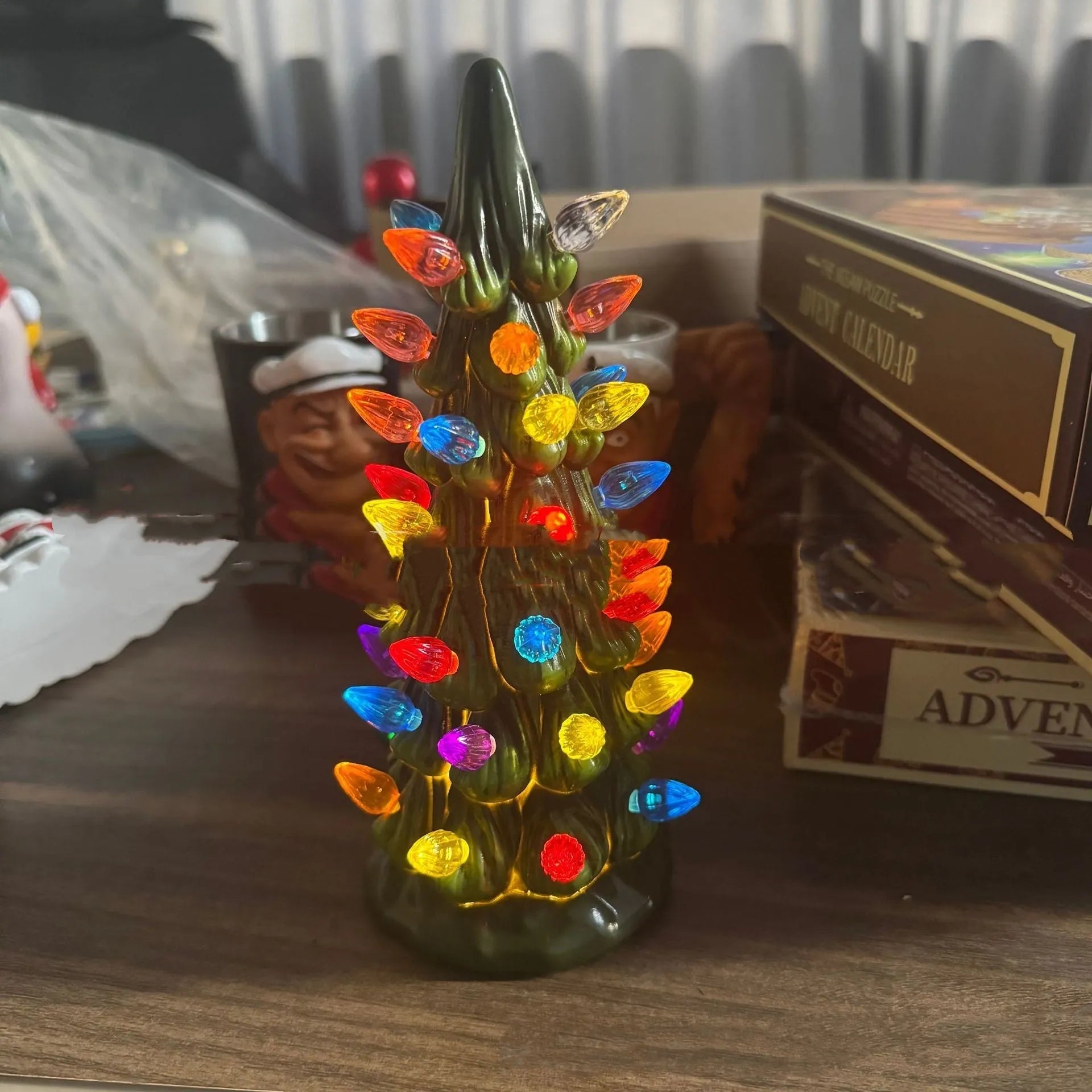 A decorative resin Christmas tree ornament with built-in LED lights, shown in European style.