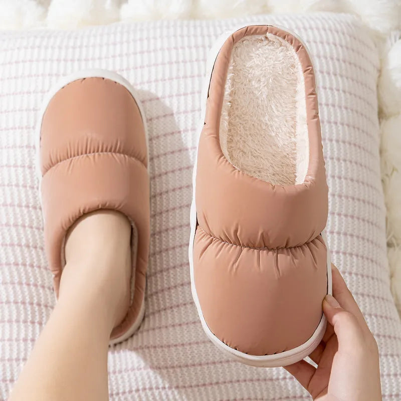 Pair of down cotton indoor slippers with artificial leather upper and thick rubber sole.