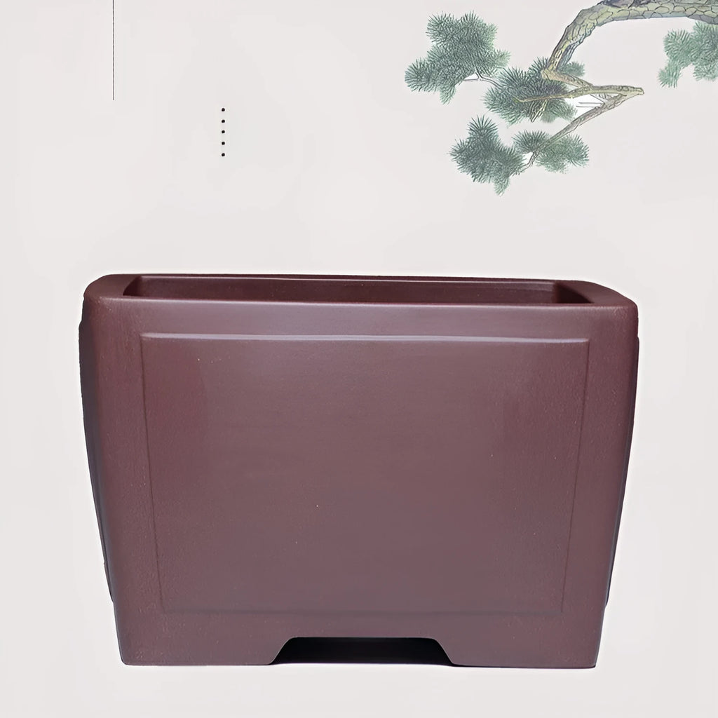 A square purple clay flower pot for succulents or bonsai plants on a tabletop.