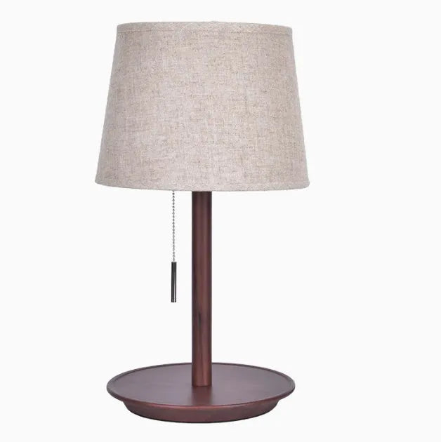 Walnut coloured solid wood table lamp with white cloth lampshade and black cable switch.