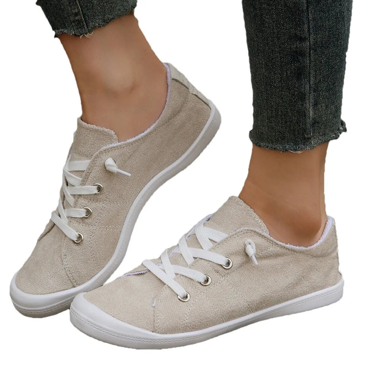 Women's creamy white low-top fabric sneakers with a casual design and rubber sole.
