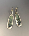 Close-up of women's geometric alloy earrings with a white and grey marble pattern.