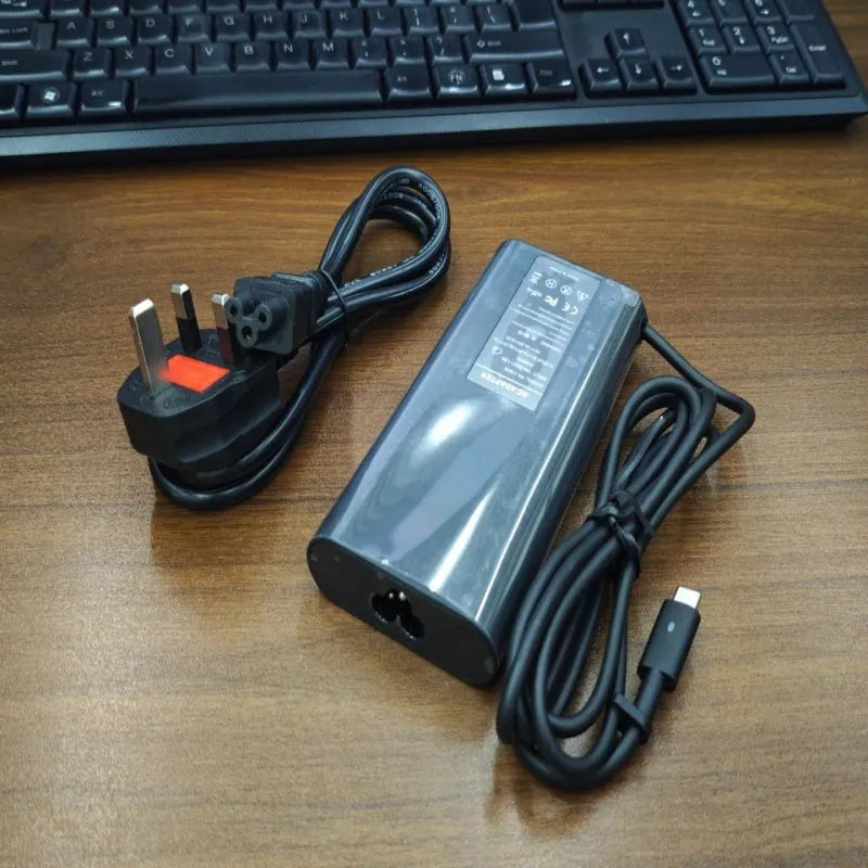 Black 65W Type-C laptop power adapter with a set of interchangeable international plug heads.