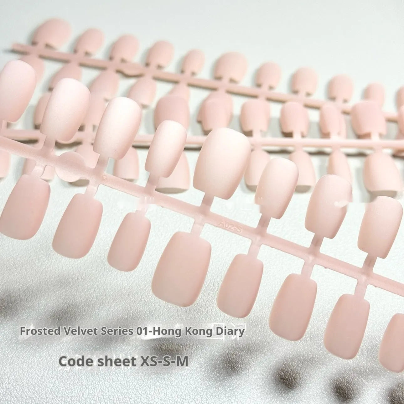 Set of frosted velvet false nails with Cat's Eye effect in short ladder sizes XS, S, and M on a clear background.