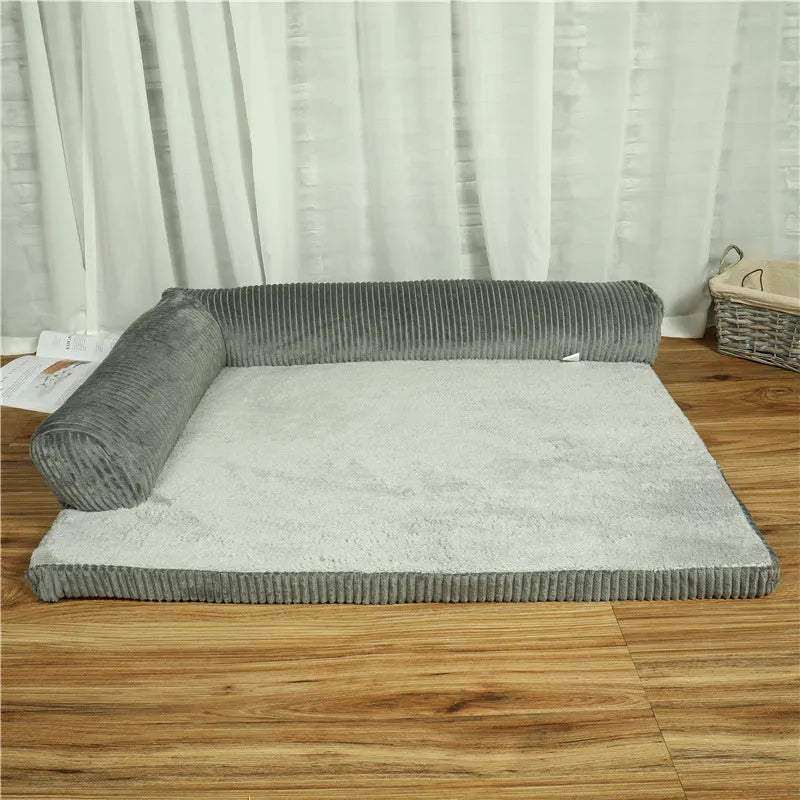 Grey corduroy dog sofa bed with raised sides on a wooden floor, showing its non-slip base.