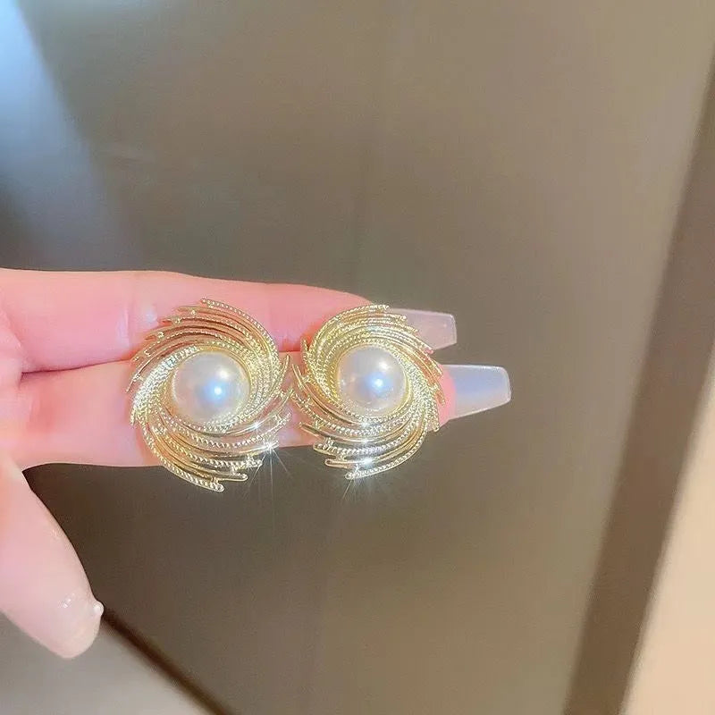 A pair of vintage floral-shaped alloy earrings with a single pearl centre and electroplated finish.