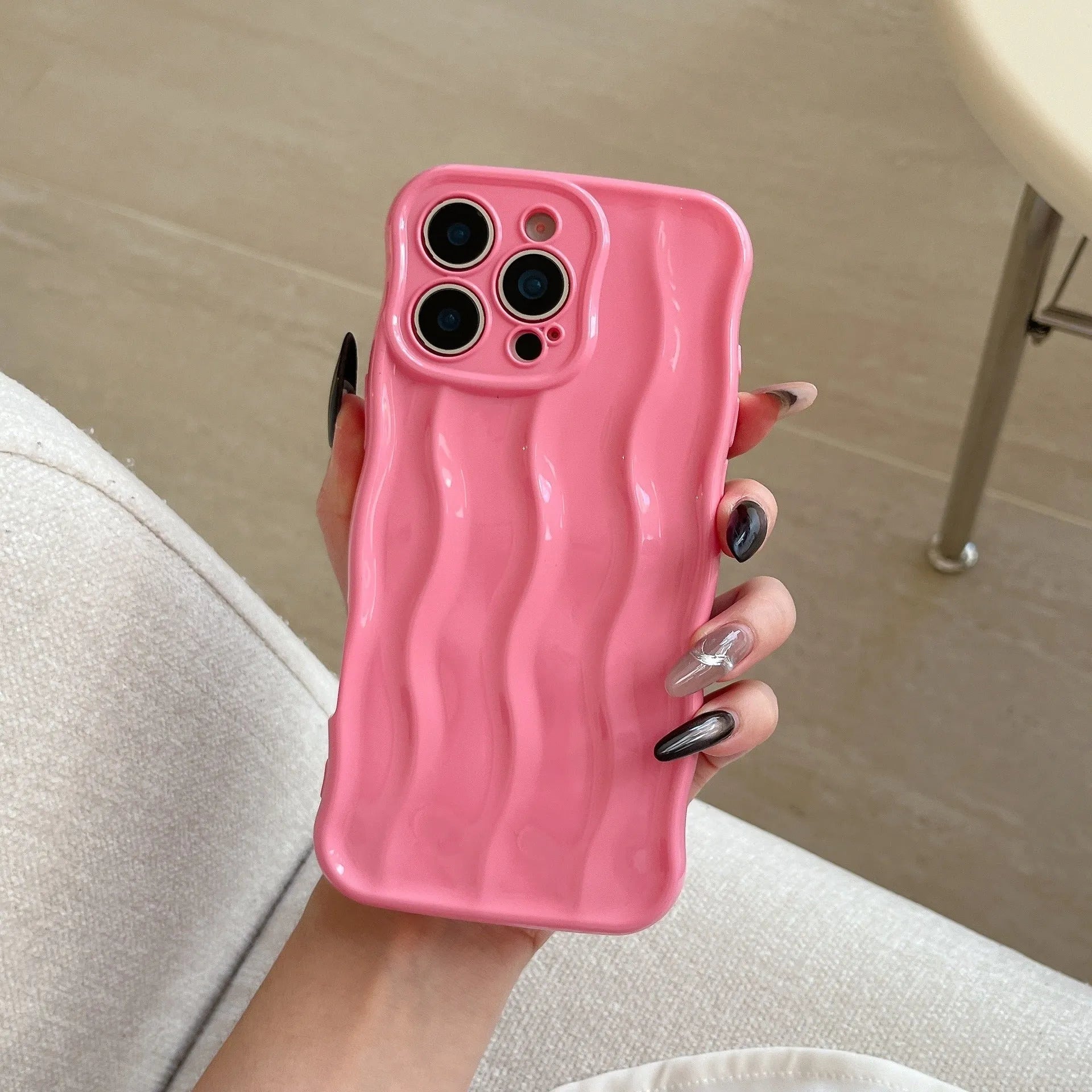 Electroplated three-dimensional wave stripe protective case for iPhone 17 on a table.