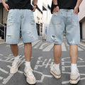 Light blue ripped denim shorts with distressed detailing and loose straight cut fit