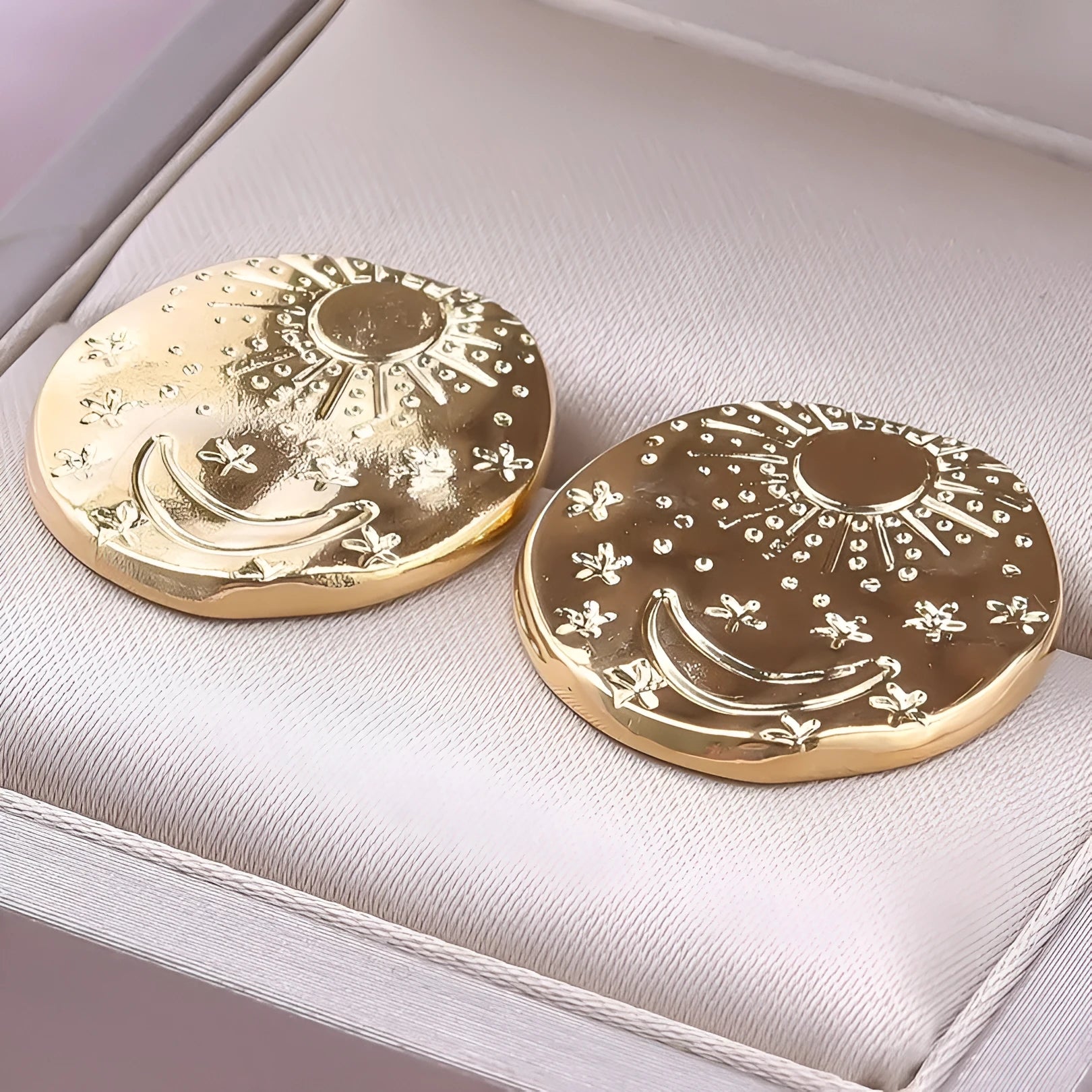 A pair of geometric shell design stud earrings in stainless steel with a gold or silver electroplated finish.