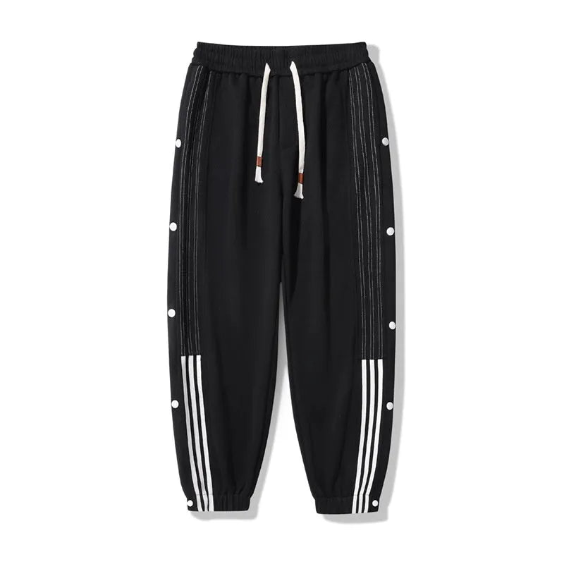 Men's black loose-fit sweatpants with ankle ties and a drawstring high waist on a neutral background.