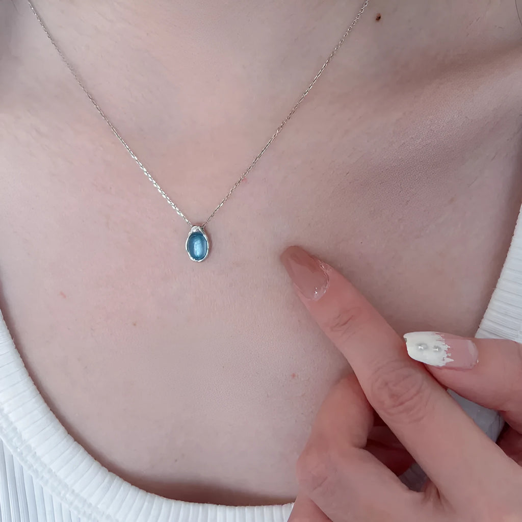 Navy blue water drop pendant necklace with geometric copper design on cross chain