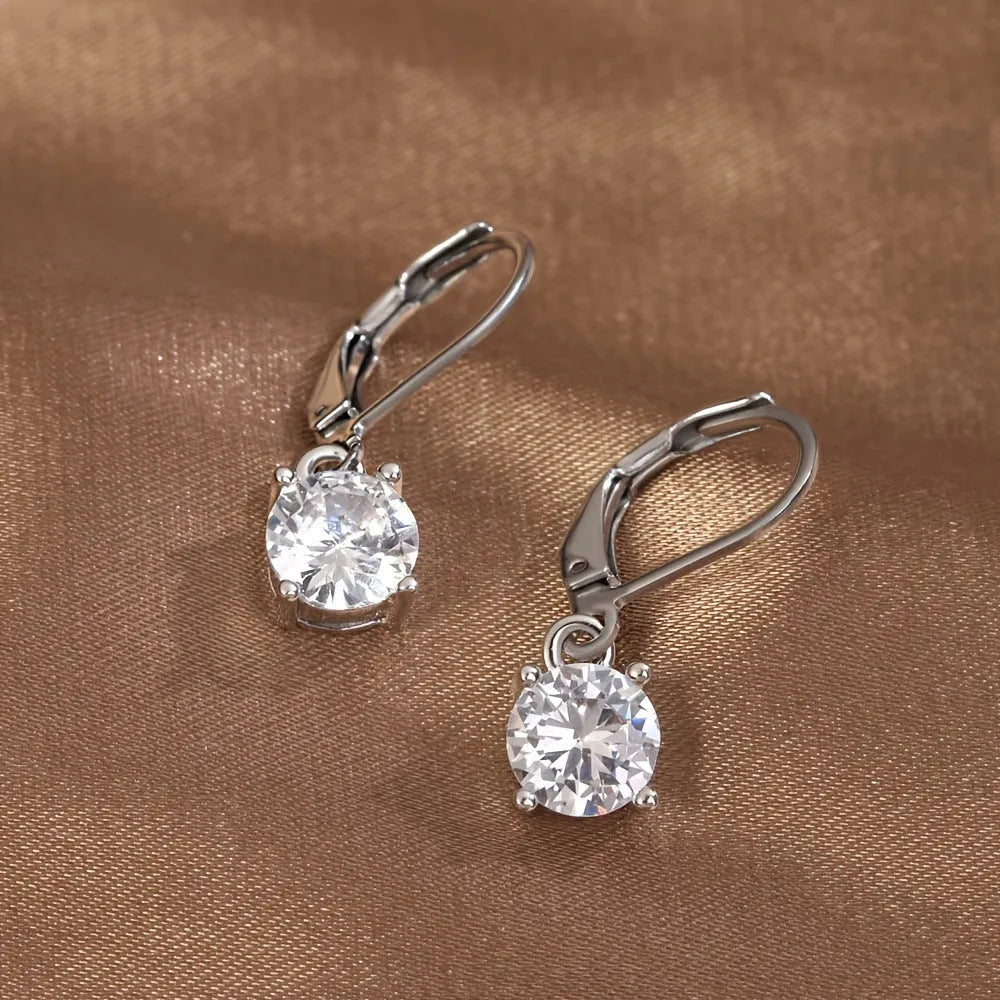 Silver-toned cubic zirconia stud earrings with 4mm round stone in claw setting on white background