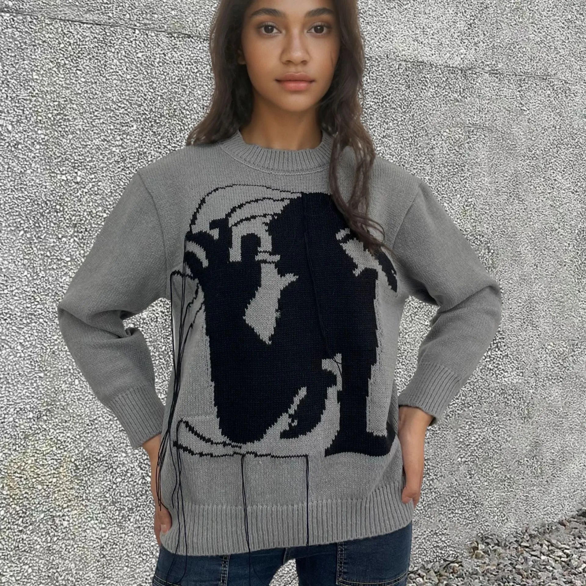 Grey women's loose alpaca wool sweater with a round neck, regular sleeves, and a long tassel detail.