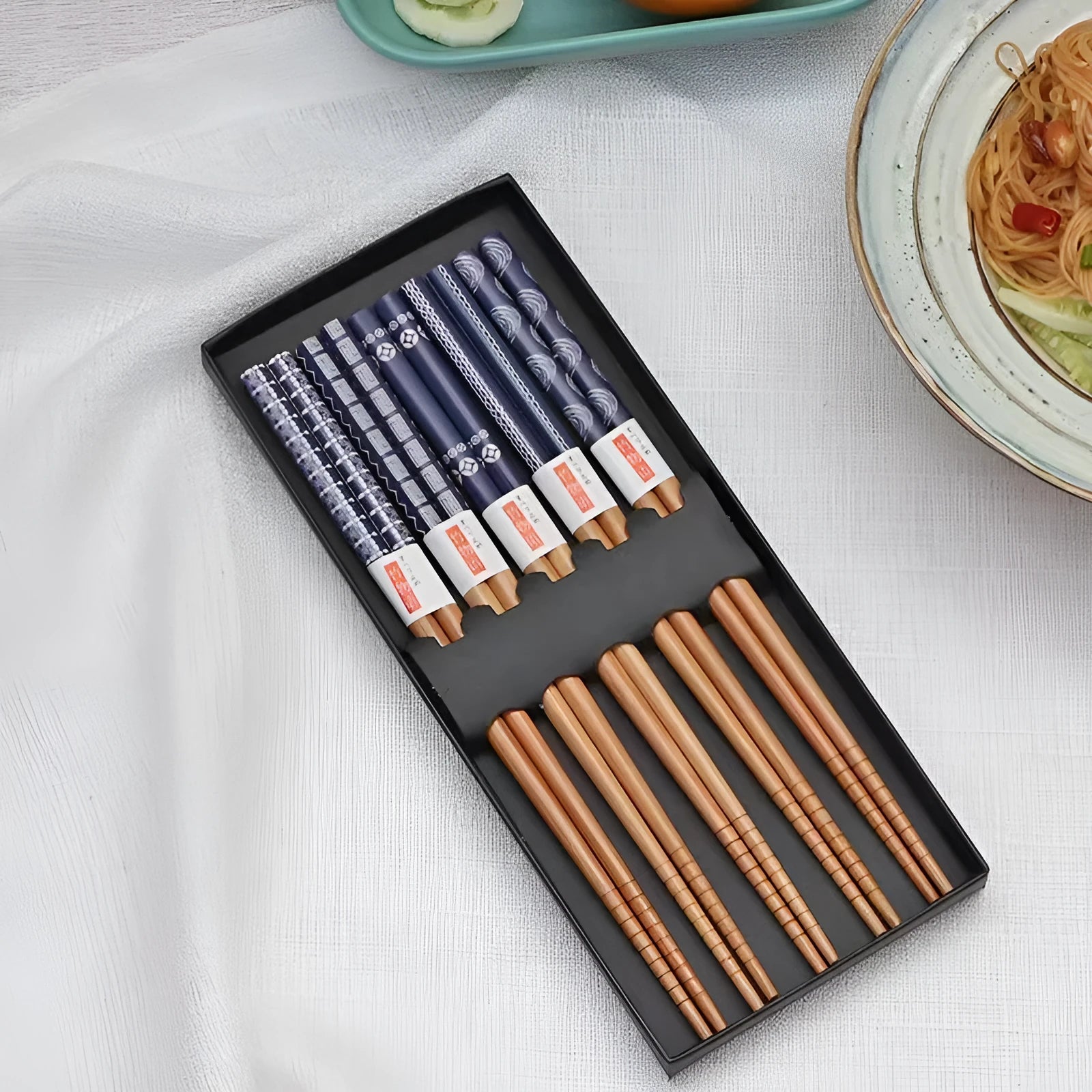 Set of Japanese-style patterned bamboo chopsticks showing lucky cat and elegant blue designs with gift box packaging