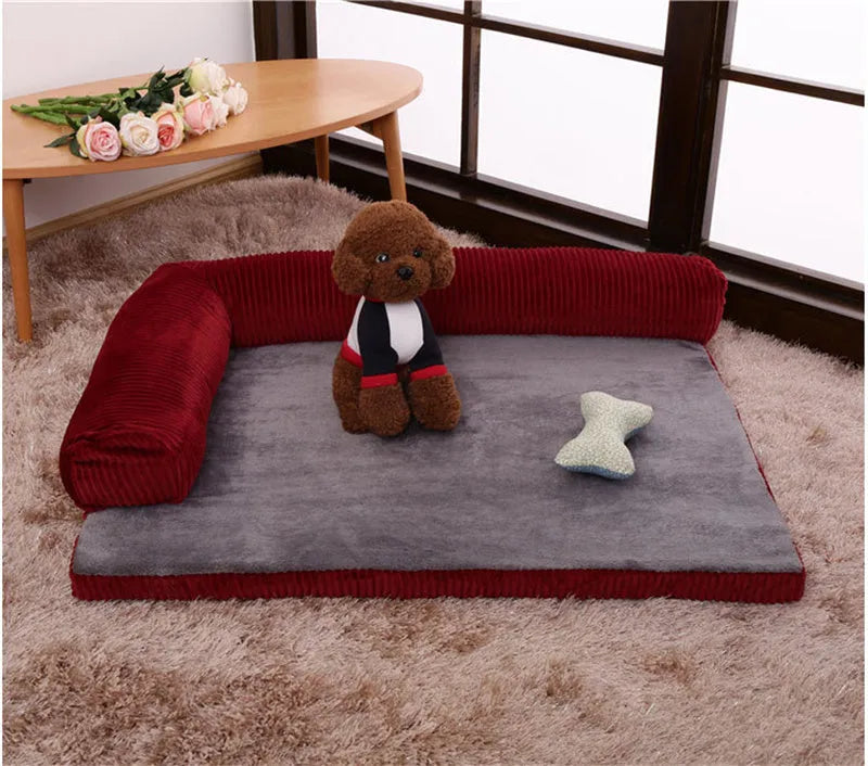 Grey corduroy dog sofa bed with raised sides on a wooden floor, showing its non-slip base.