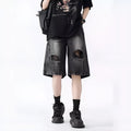 Washed black denim shorts with ripped details and loose retro fit showing front view