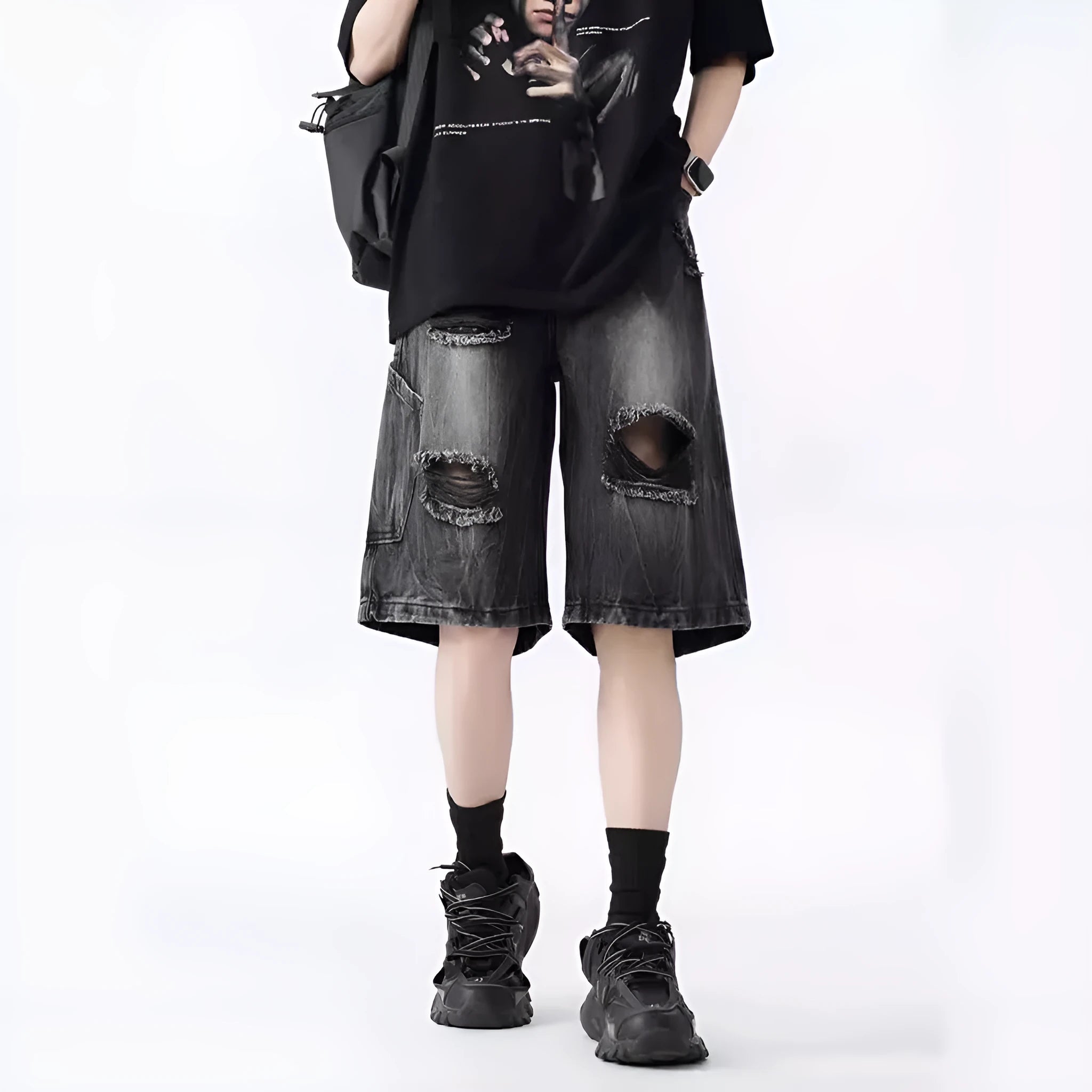 Washed black denim shorts with ripped details and loose retro fit showing front view