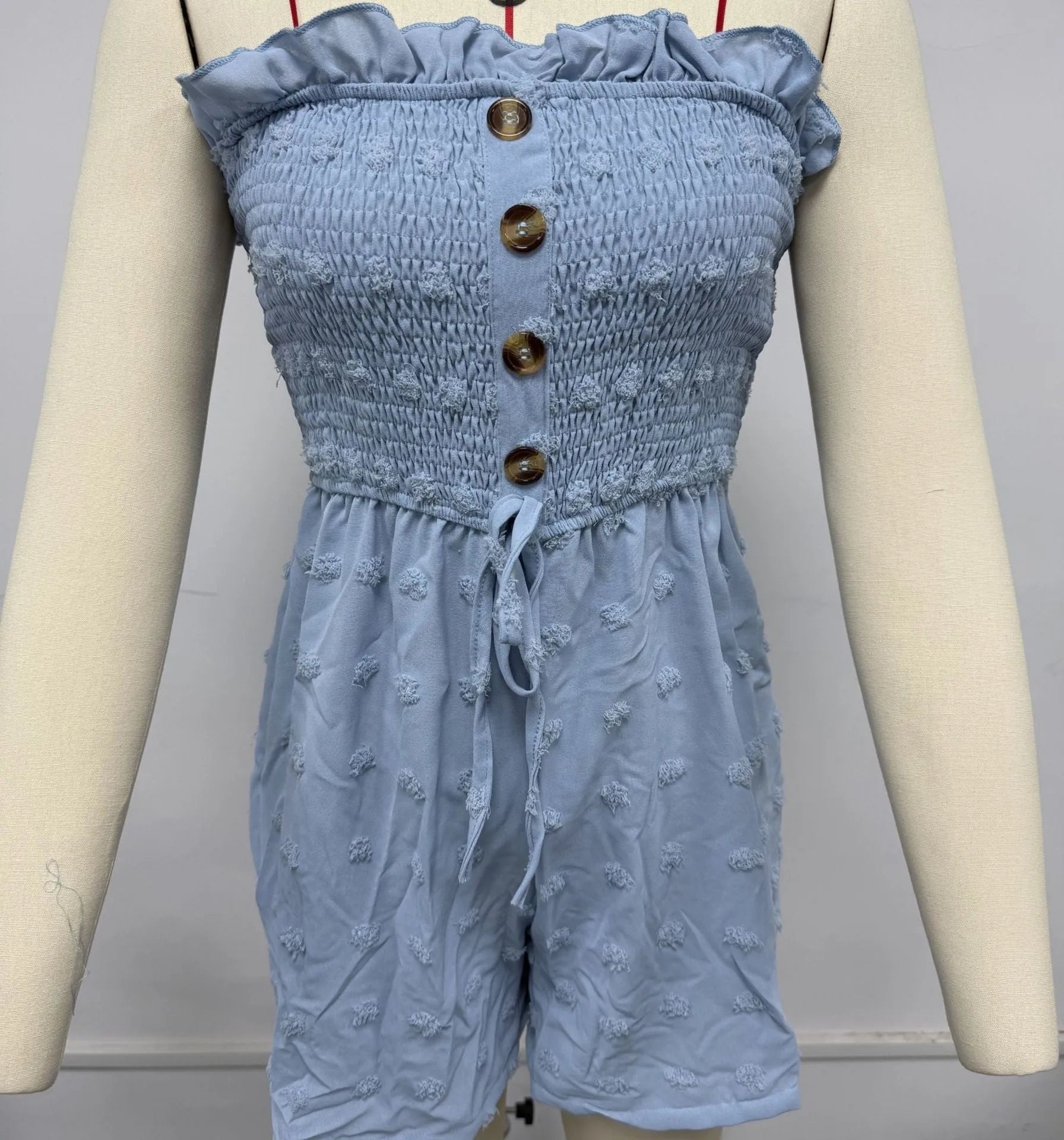 Blue women's off-shoulder sleeveless jumpsuit with button detail on mannequin