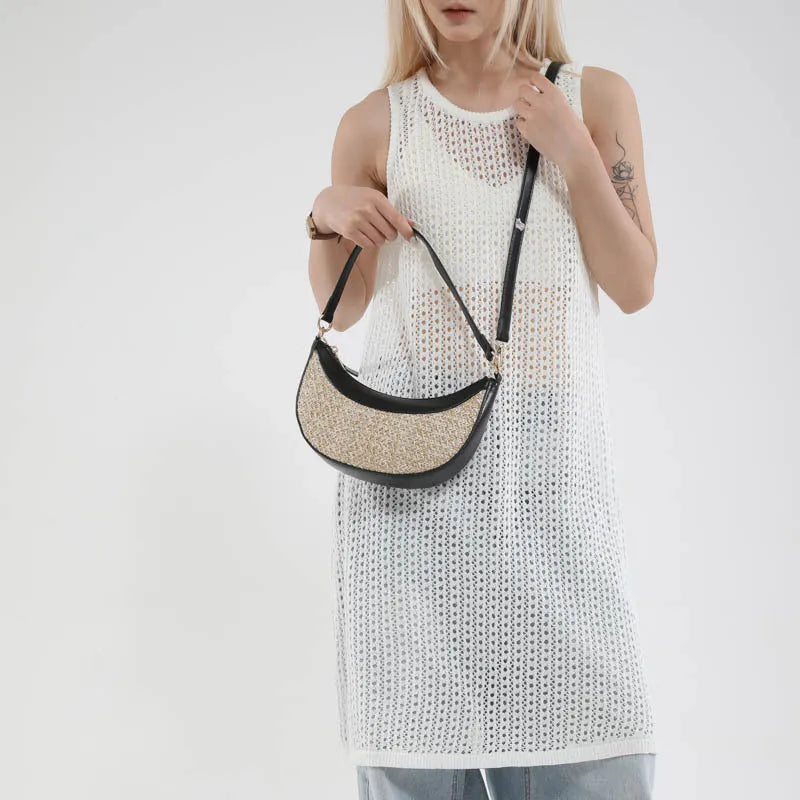 Hard woven straw dumpling-shaped crossbody shoulder bag with organised interior compartments.