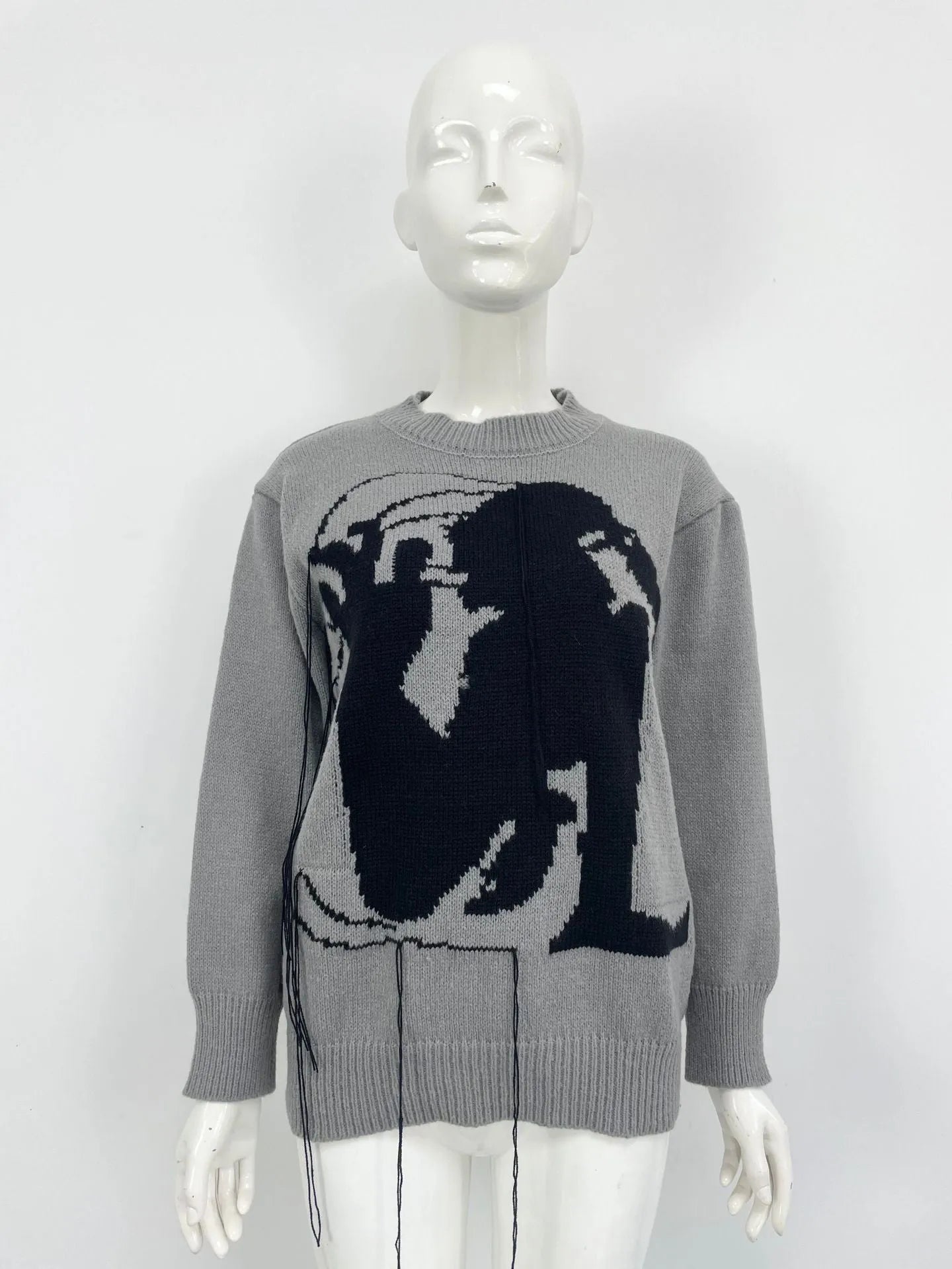Grey women's loose alpaca wool sweater with a round neck, regular sleeves, and a long tassel detail.
