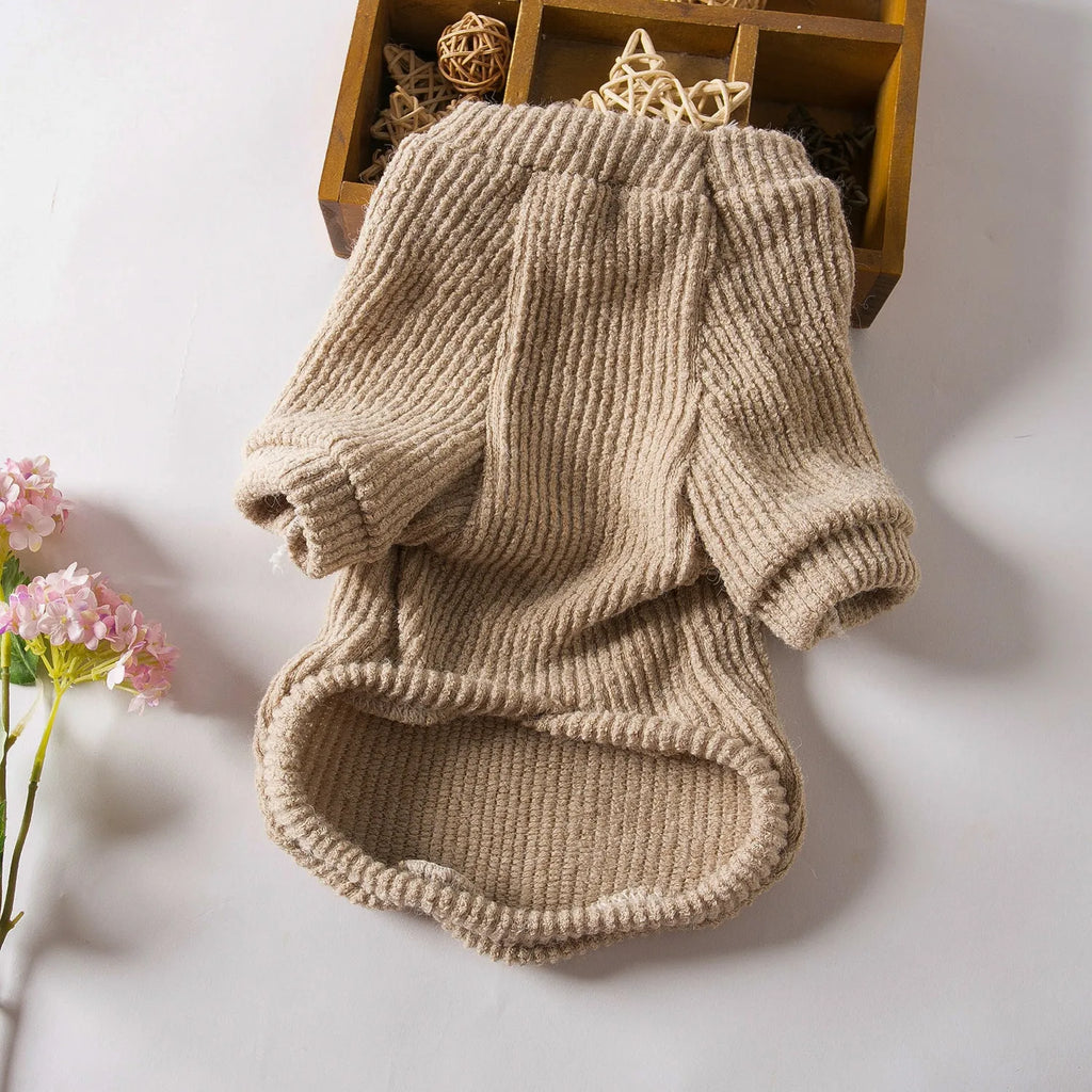 Brown knitted pullover sweater on a small dog, showing four-leg design for full coverage.