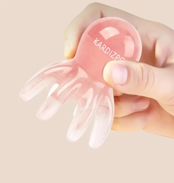 Pink octopus-shaped natural resin massage comb for facial and head massage on a plain background.