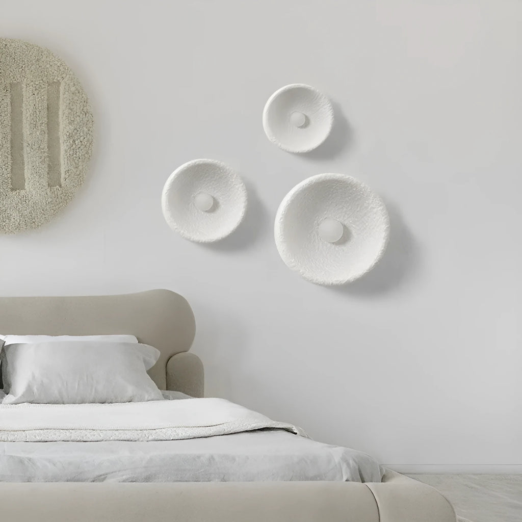 Japanese-style simple silent wall lamp with white resin shade on a wall.