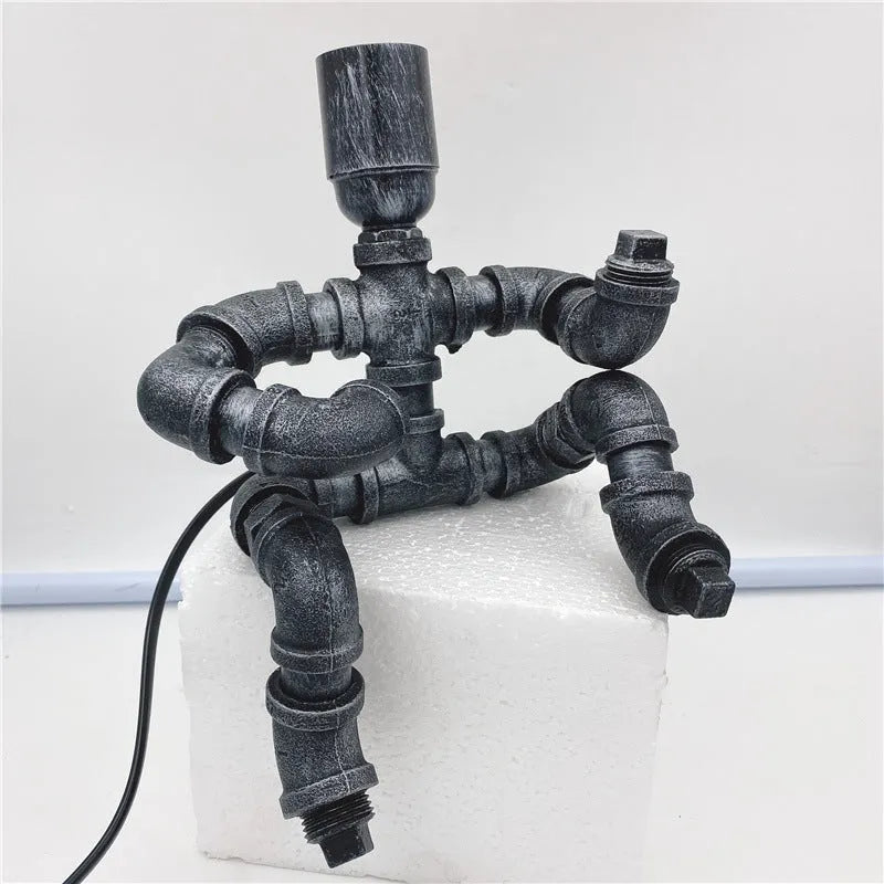 Industrial retro table lamp made from iron water pipes in vintage colour on a wooden desk