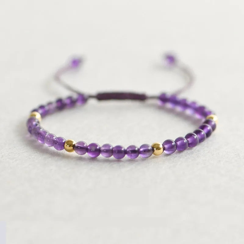 Women's geometric braided rope bracelet with freshwater pearls, amethyst, pomegranate, and red beads.