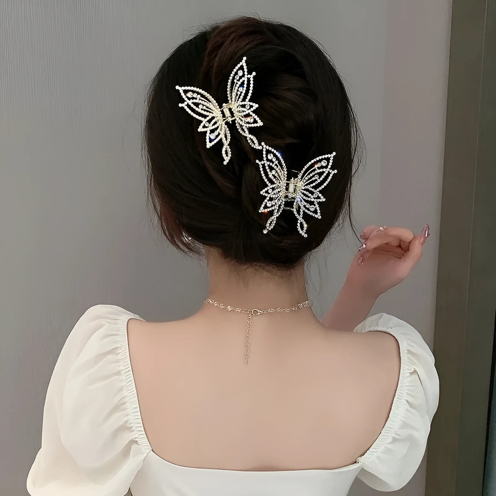 Butterfly-shaped alloy hair clip for women, shown in rhinestone and pearl style options
