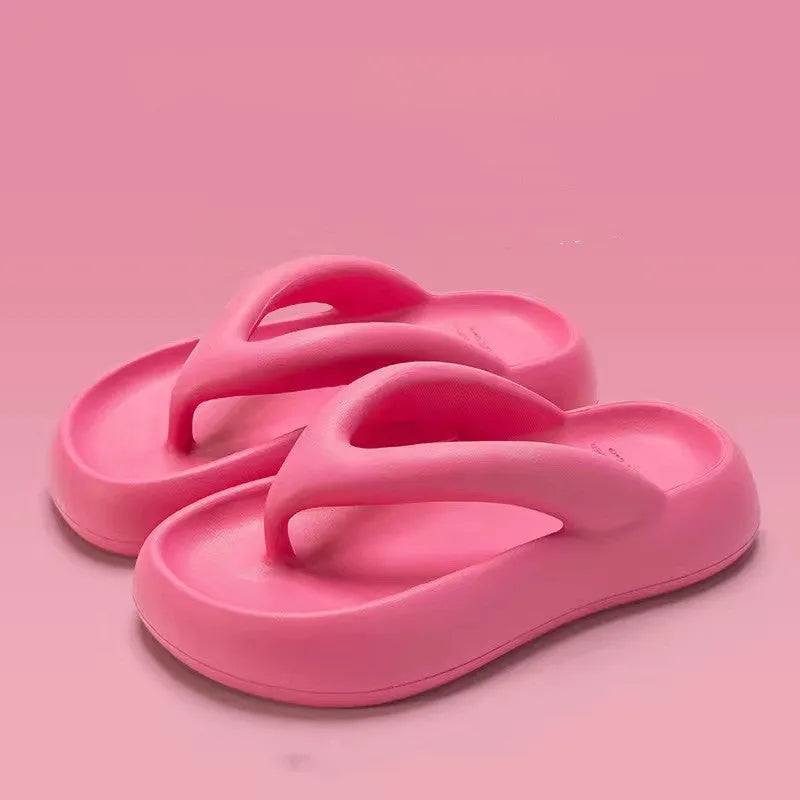 A pair of thick-soled flip-flops with a bow detail on the upper, shown in a solid colour.