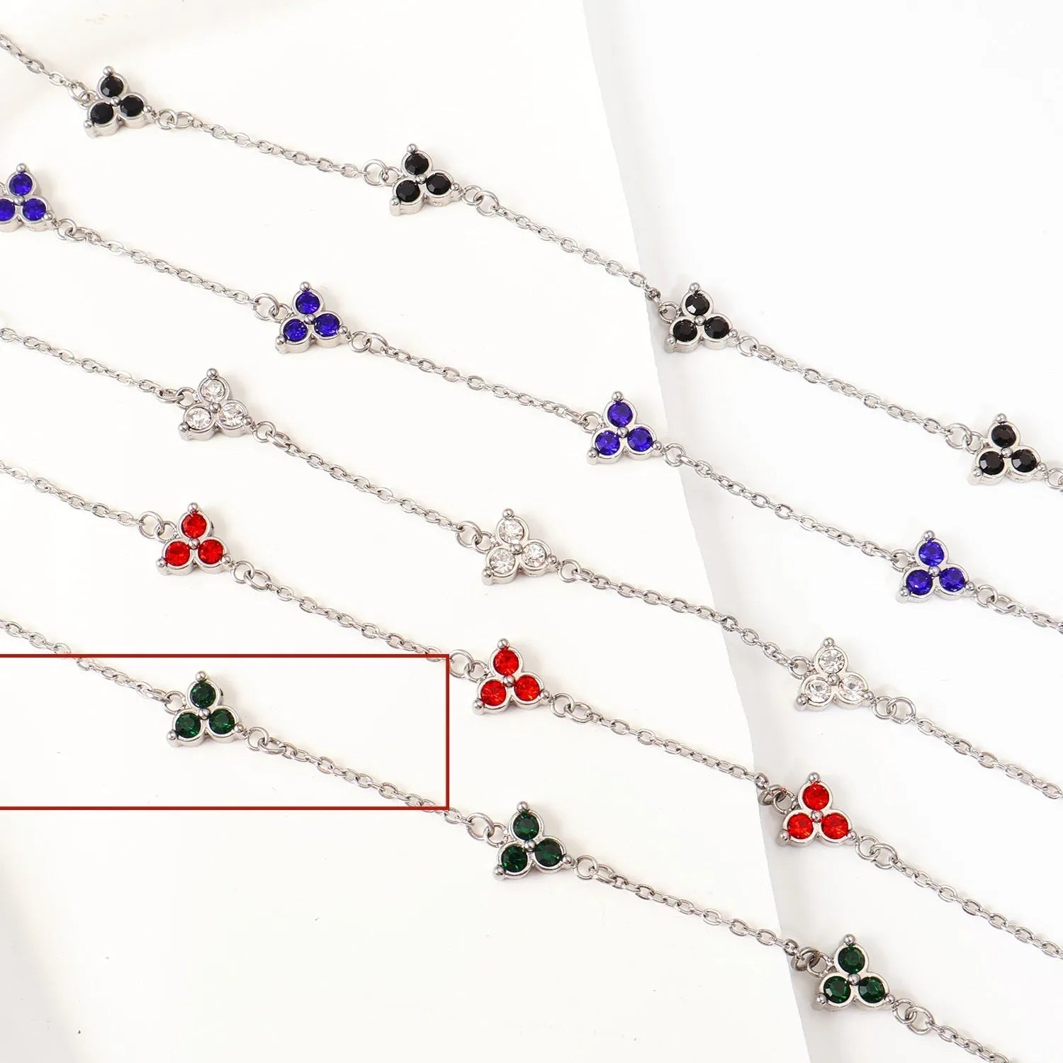 Women's stainless steel bracelet with a geometric triangle pendant, shown in gold and steel tone options with coloured stones.