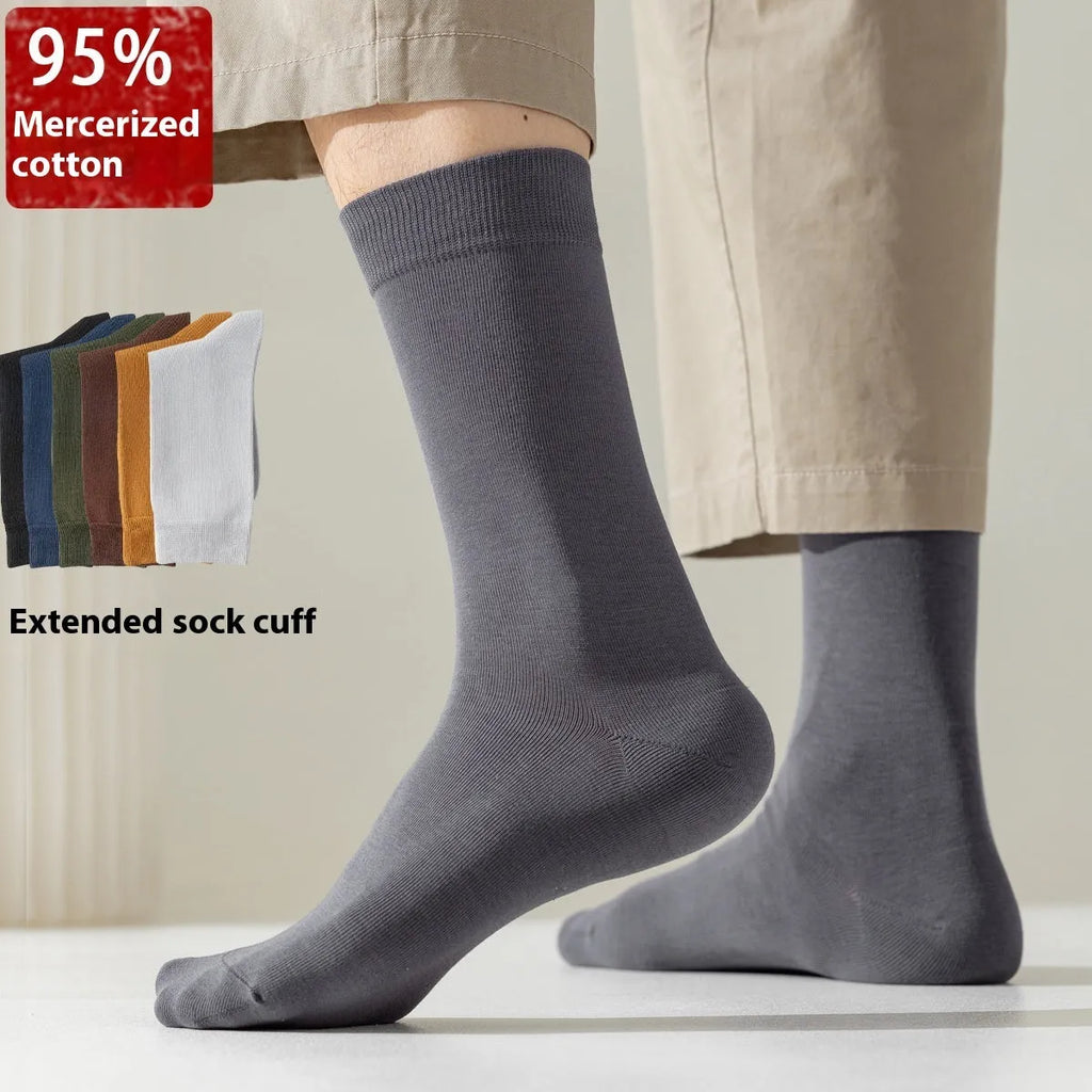 Men's solid colour mid-calf business socks made from combed cotton in various colours on a plain background.