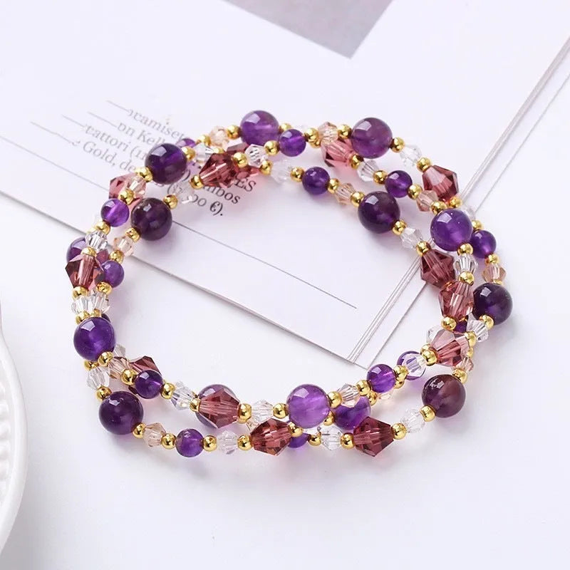 Close-up of a women's hand-made three-ring crystal bracelet with colourful beads on an adjustable rope.