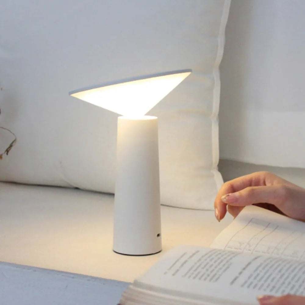 Black USB touch sensor reading lamp with tilted head on a wooden desk