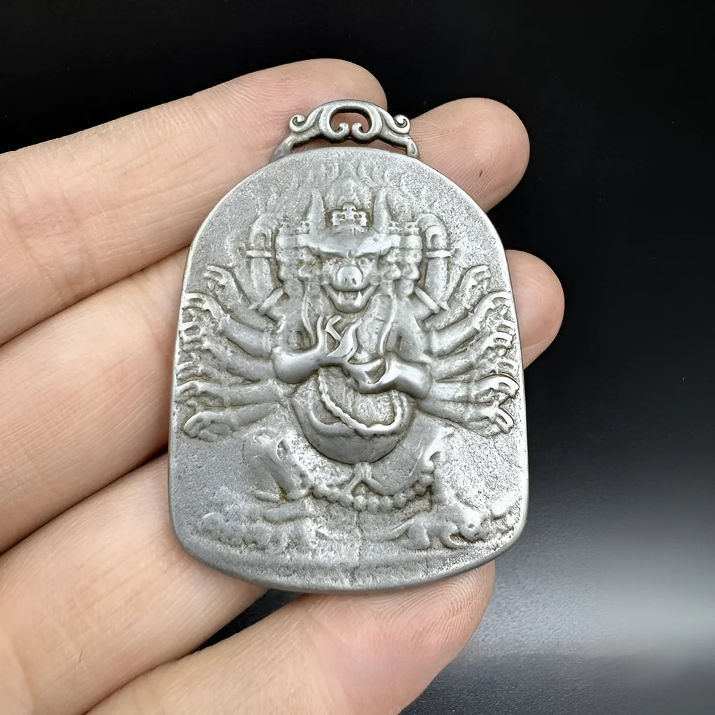 Close-up of a geometric iron pendant ornament in a Chinese style depicting the Aryaacalanatha Yamantaka motif.