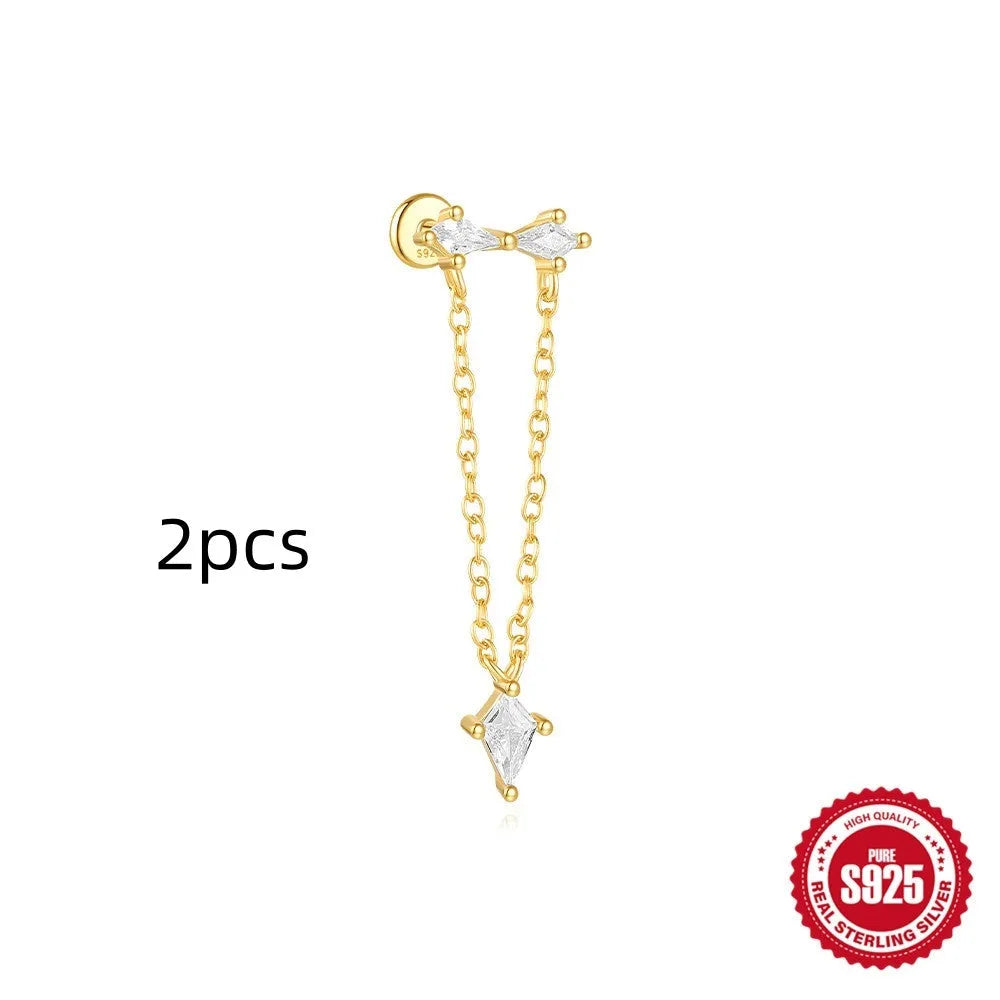 Geometric kite-shaped sterling silver earring with rhinestone head and gold chain tassel.