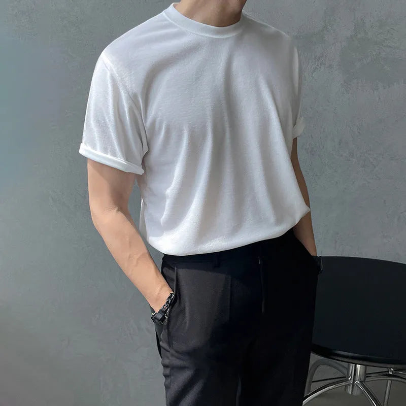 A man wearing a slim fit black cotton T-shirt with a round neck and half sleeves.