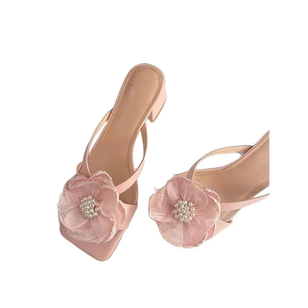 Women's cream-white satin sandals with a chunky heel and square toe on a light background.