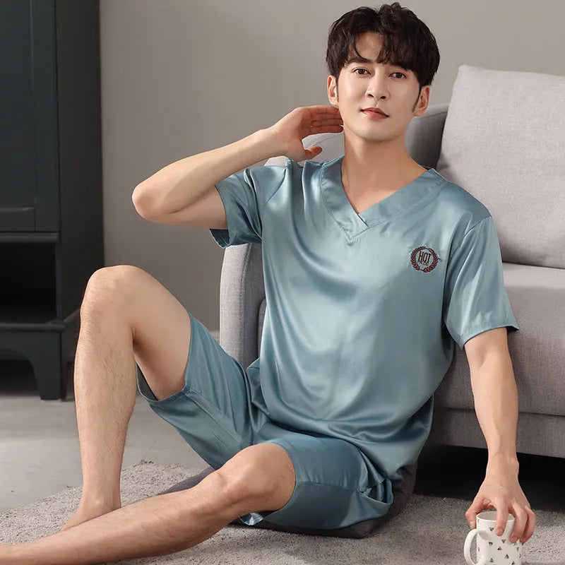 Man wearing a loose light blue short-sleeve pyjama shirt and matching shorts, illustrating the ice silk sleepwear set.