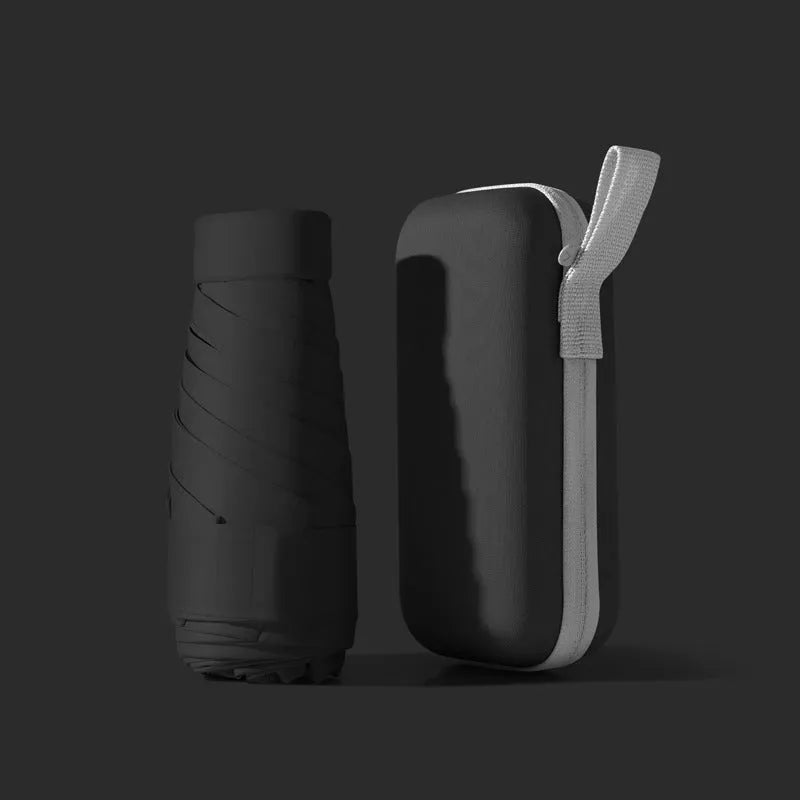 Ultra-light six-fold sun umbrella open, showing NC fabric canopy and rubber handle, next to its compact folded size in a capsule box.