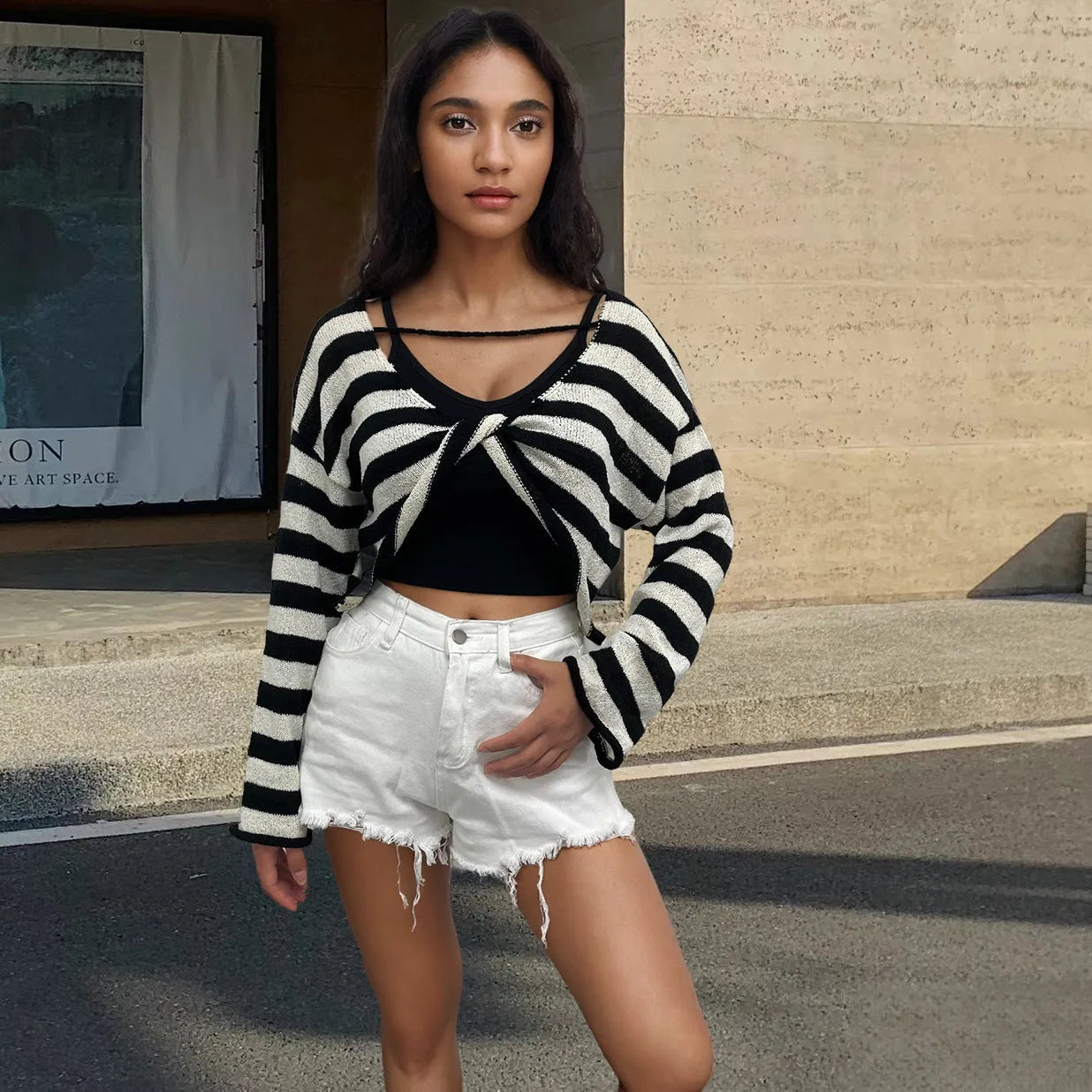 Striped long-sleeved cotton sweater with an exposed navel design on a model